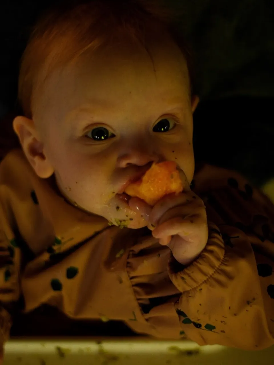 Baby tasting carrot, candid family moment at home