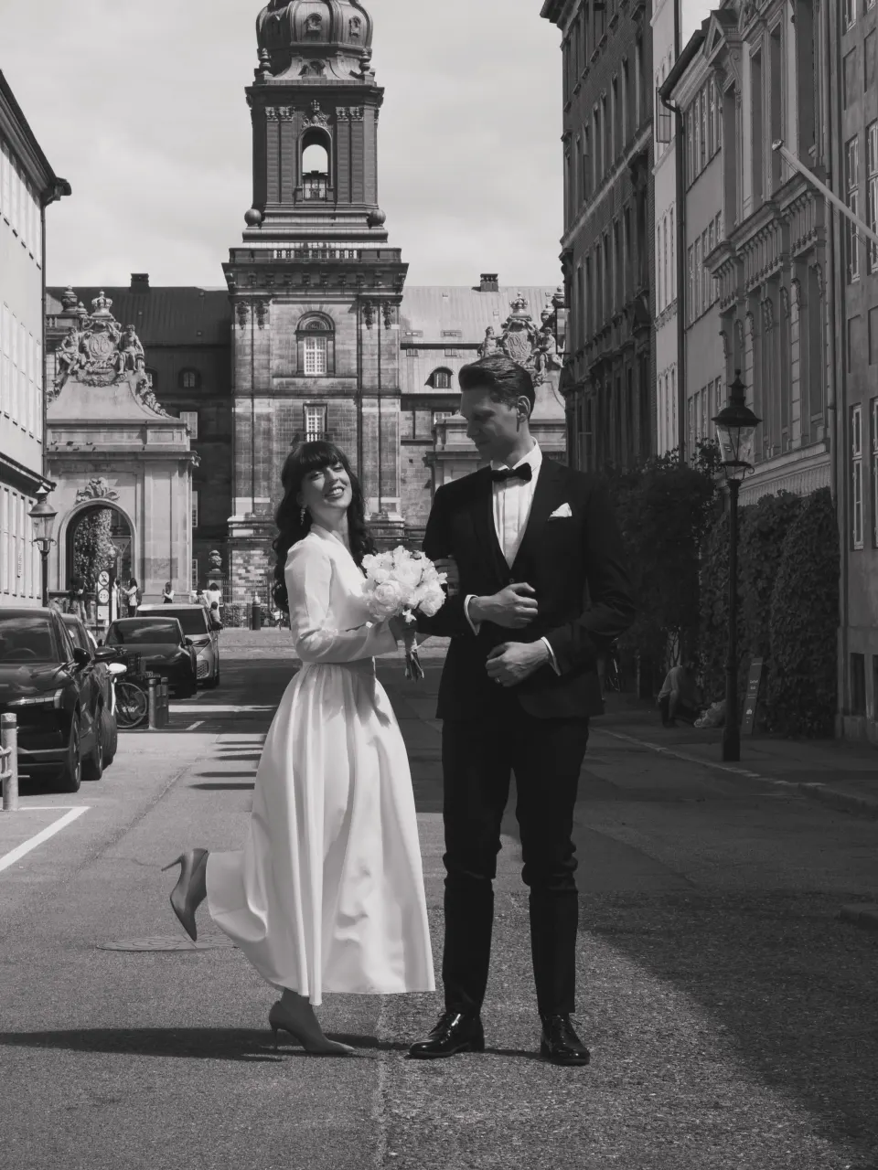 Bride and groom walking through Copenhagen old town after their wedding, black and white